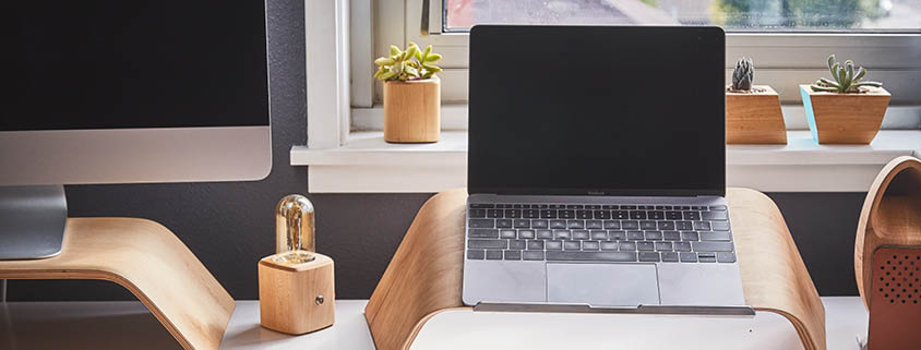 Symbolbild Arbeitsplatz: Ein Schreibtisch auf dem ein Laptop und ein angeschnittener Computer steht